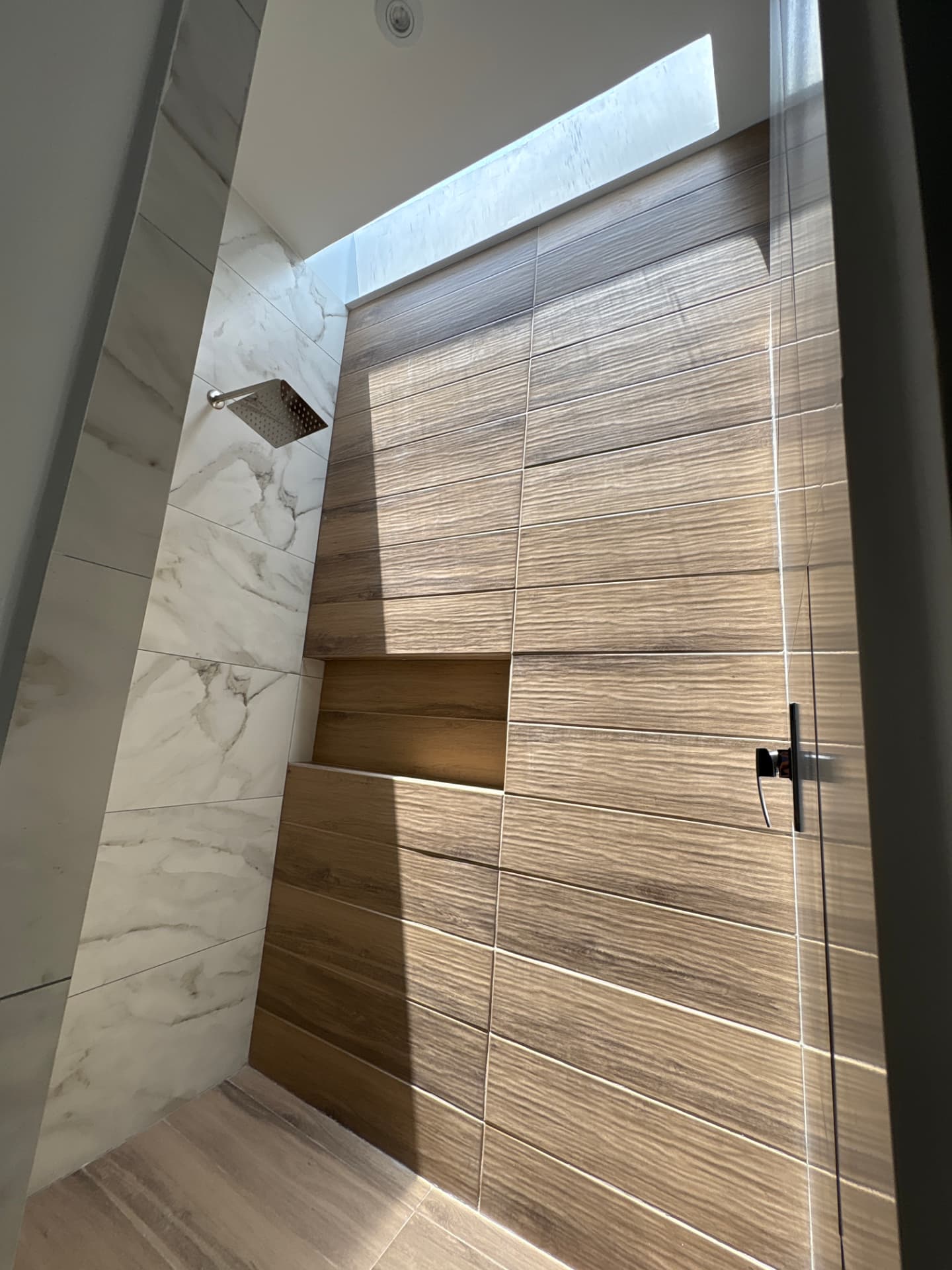 Regadera con muro de cerámica tipo madera